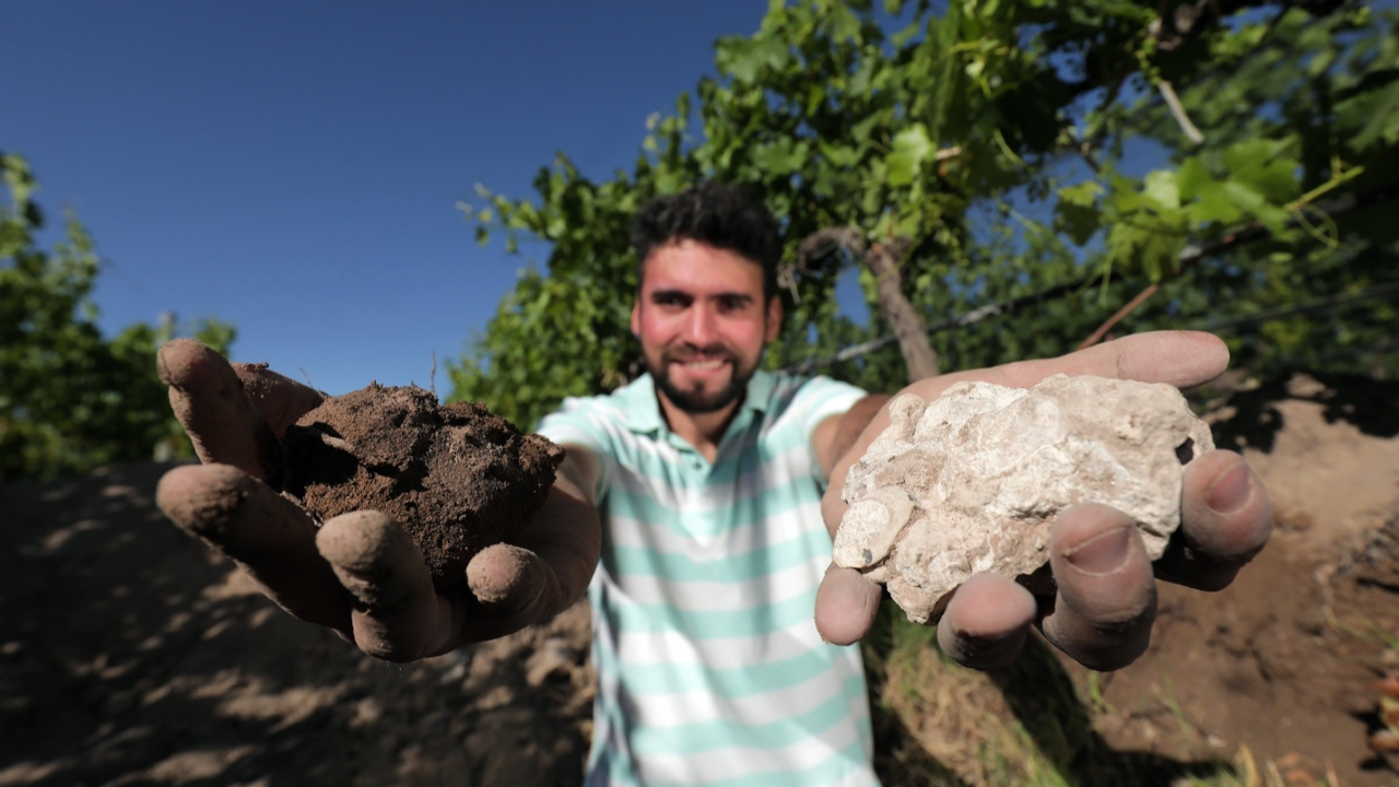 A winemaker at Domaine Bousquet’s organic vineyard holds dirt and clay in his hands