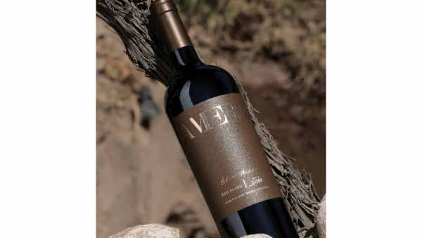 A bottle of Ameri red blend, one of Domaine Bousquet’s popular organic wines, lays against a tree branch