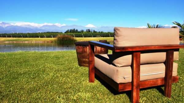 A comfy chair on a field overlooking a lake ready for someone to sit in and have a virtual wine tasting